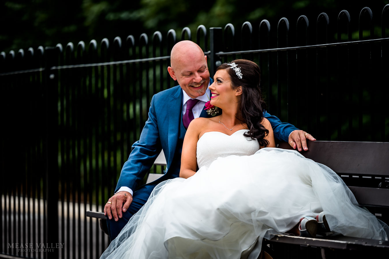 Photograph of bride and groom sitting on a bench in Solihull